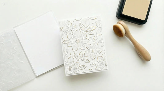 Handmade card with a 3D embossed background beside an embossing folder and ink blending tools.