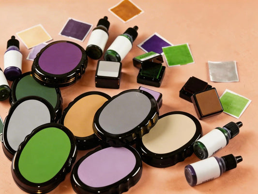 Flat lay of colorful ink pads, ink refill bottles, and paper swatches on a peach background.